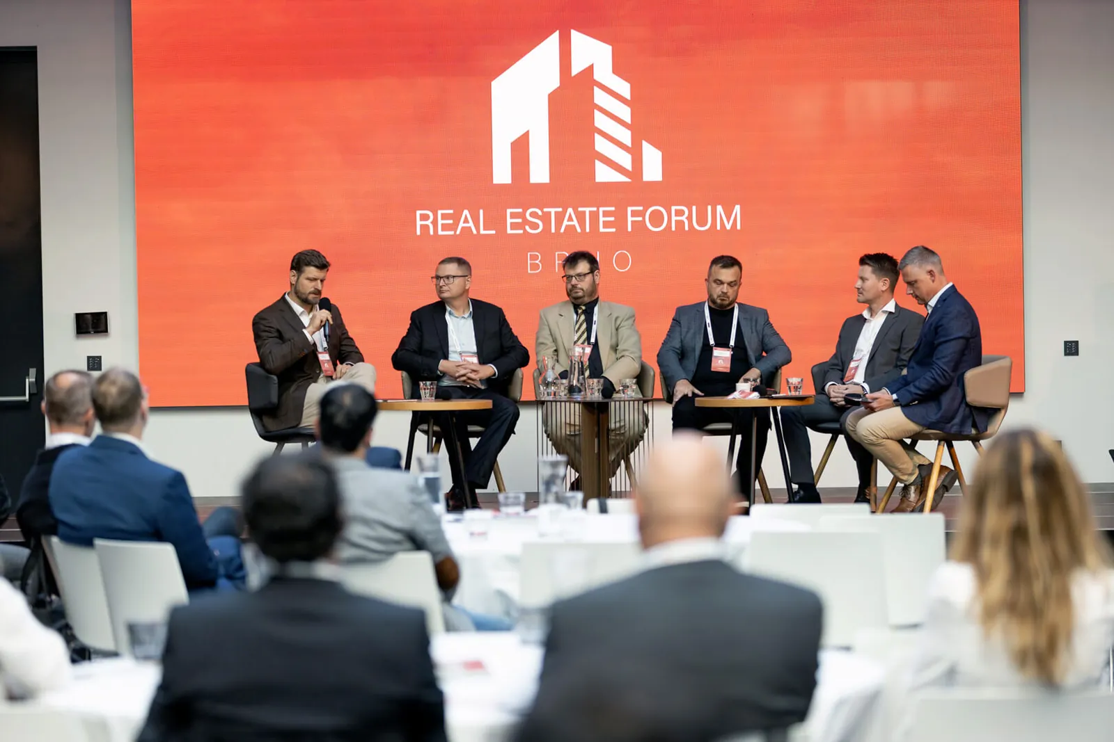 Diskusní panel Real Estate Fora v Brně — šest panelistů na pódiu